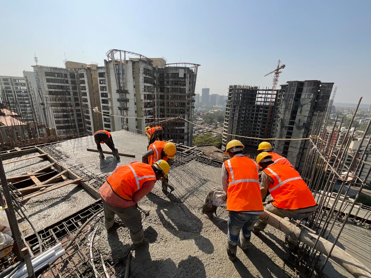 Mastering the First Impression: Your intriguing post title goes here Workers in safety gear building a skyscraper with a city skyline backdrop.